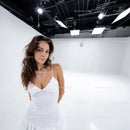 Young Woman in White Dress Standing in Modern Studio