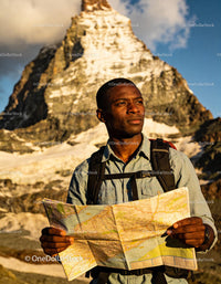 Explorer Studying Map in Mountainous Sunset Landscape