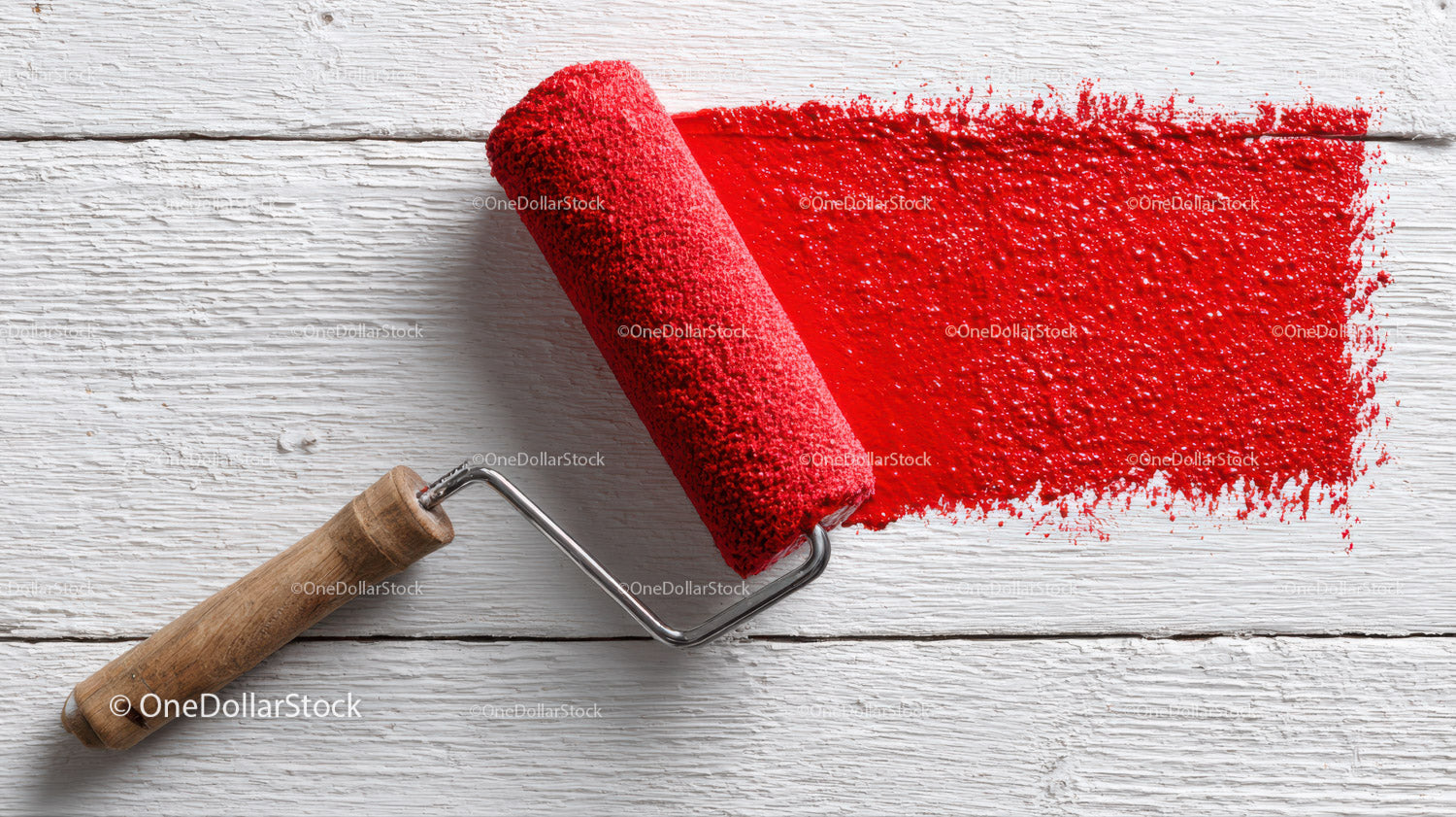 Red Paint Application with Roller on White Wooden Surface