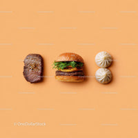 Gourmet Burger with Lettuce and Tomato Next to Grilled Steak and Dumpling