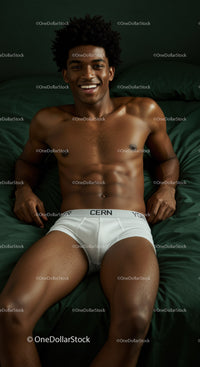 Smiling young man relaxing on dark green bed
