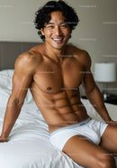 Smiling muscular man relaxing in white underwear on bed