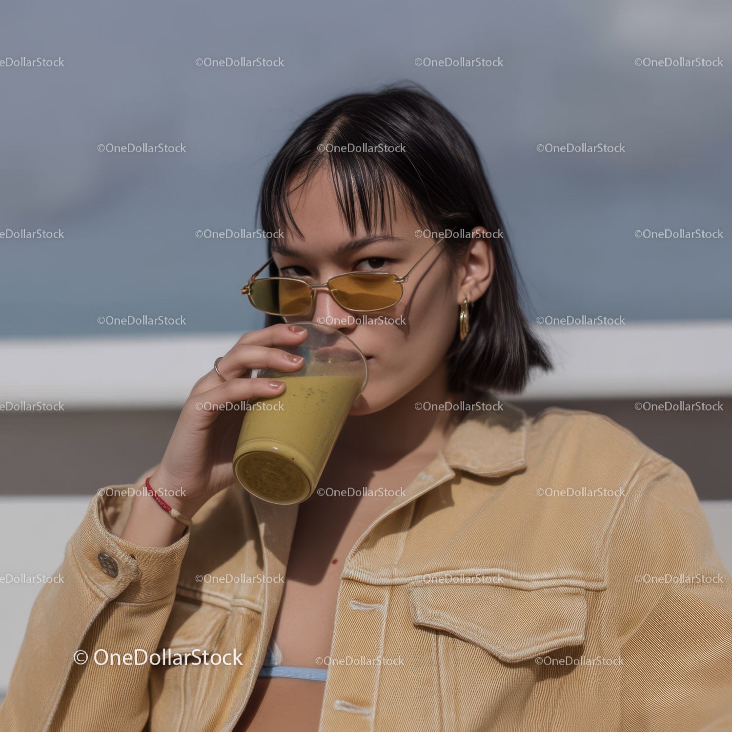 Stylish woman drinking smoothie in trendy outdoor setting