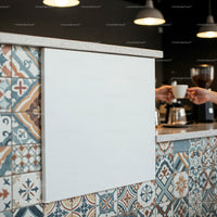 Barista handing coffee cup over colorful tiled counter
