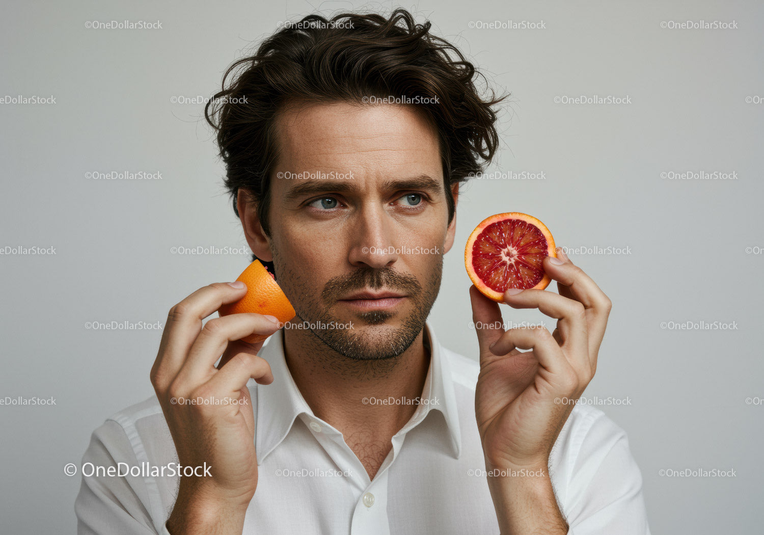 Man Holding Blood Orange Slice and Orange Fruit on Neutral Background