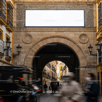 Historic stone archway framing lively old town street