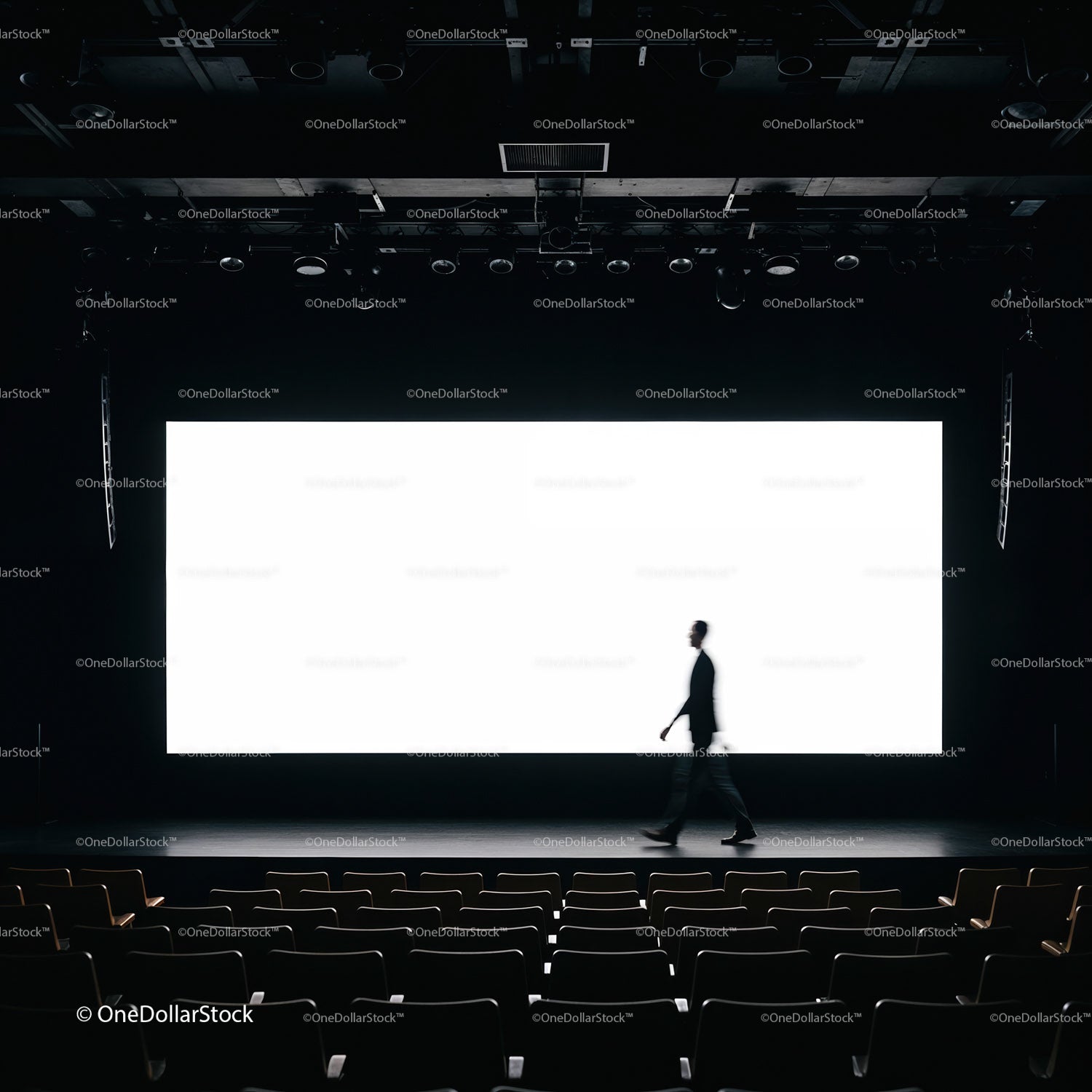Silhouette of man walking on stage in empty theater