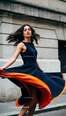 Elegant woman twirling in stylish black and orange dress