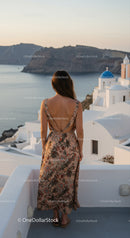 Woman in floral dress overlooking Santorini sea view
