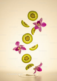 Floating kiwi slices with vibrant orchid flowers