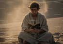 Man Sitting Alone in Desert Reading a Book During Sunset