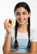 Smiling Girl with Braided Hair Holding Peach on White Background