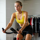 Woman Cycling Indoors in Yellow Sports Bra for Fitness