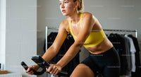 Woman Exercising on Indoor Bike in Yellow Sportswear