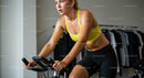 Woman Determinedly Exercising on Spin Bike