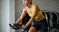 Woman Determinedly Exercising on Spin Bike