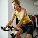 Focused Woman on Indoor Bike Exercising in Yellow Sportswear