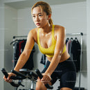 Determined Woman Exercising on Indoor Cycling Machine
