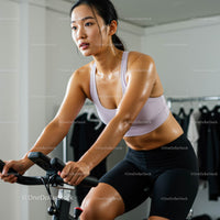 Woman Engaged in Intense Indoor Cycling Workout