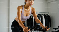Focused Woman on Exercise Bike in Modern Gym Setting
