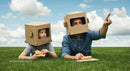 Father and Son Bonding with Cardboard Helmets on Grass
