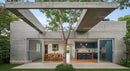 Modern Concrete Structure with Outdoor Dining and Tree Canopy