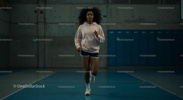 Focused Woman Running in Indoor Gym Setting