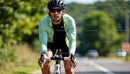 Focused Cyclist Riding on Sunny Day in Green Jacket
