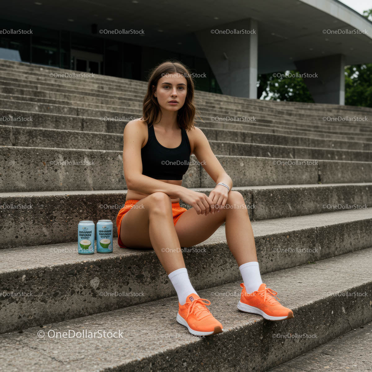 Young Woman Resting on Concrete Steps in Orange Sportswear