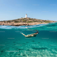 Snorkeling in Clear Waters Near a Coastal Lighthouse
