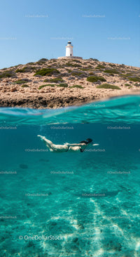 Lighthouse Overlooking Snorkeler in Crystal Clear Blue Waters