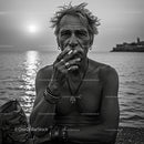 Rugged Man Smoking by the Ocean at Sunset