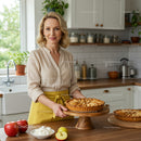 Smiling Woman Presenting Homemade Apple Pie in Cozy Kitchen