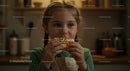 Cute Little Girl Enjoying a Sprinkle-Decorated Dessert