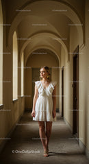 Elegant Woman in White Dress in Arched Corridor