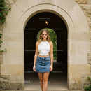 Young Woman in Denim Skirt by Stone Archway