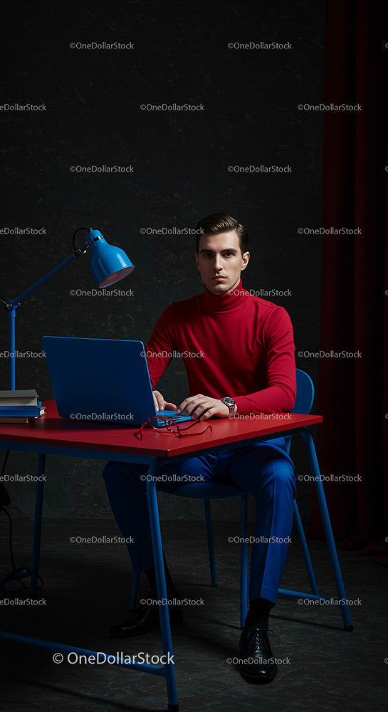 Focused Professional Man in Red Sweater and Blue Trousers
