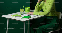 Woman in Green Attire at Minimalist Desk Workspace