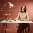 Smiling Woman Writing at Stylish Desk with Orange Background