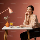 Smiling Woman in Cozy Workspace with Orange Lamp