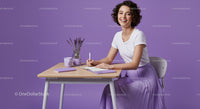Smiling Woman in Purple Skirt Writing at Desk with Lavender