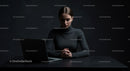 Focused Woman Working on Laptop in Dark Setting