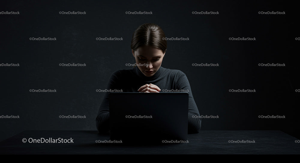 Focused Woman Working on Laptop in Dark Ambiance