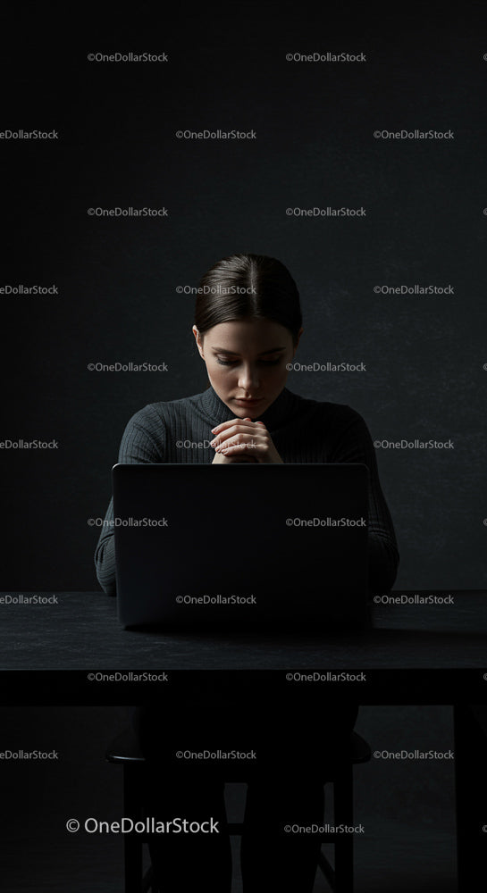 Thoughtful Woman Working on Laptop in Dark Room