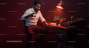 Focused Man Working Late in Red-Lit Office Space