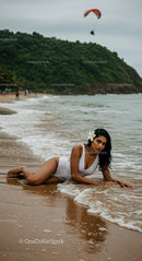 Woman in White Swimsuit Relaxing on Tropical Beach Shore