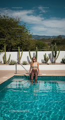 Relaxed Woman Sitting by Pool in Sunny Desert Oasis