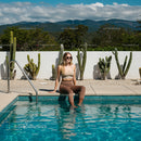 Woman Relaxing by a Poolside Cactus Garden on a Sunny Day