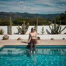 Woman Relaxing by the Pool with Desert Cacti Backdrop