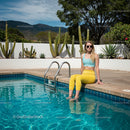 Young Woman Relaxing by the Pool with Cactus Background